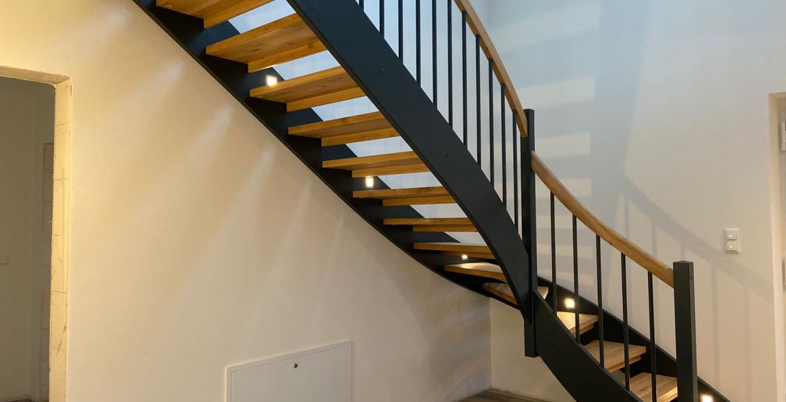 Moderne Wangentreppe aus hellem Holz und dunklem Geländer von ARKTIC Treppentechnik in Kiel