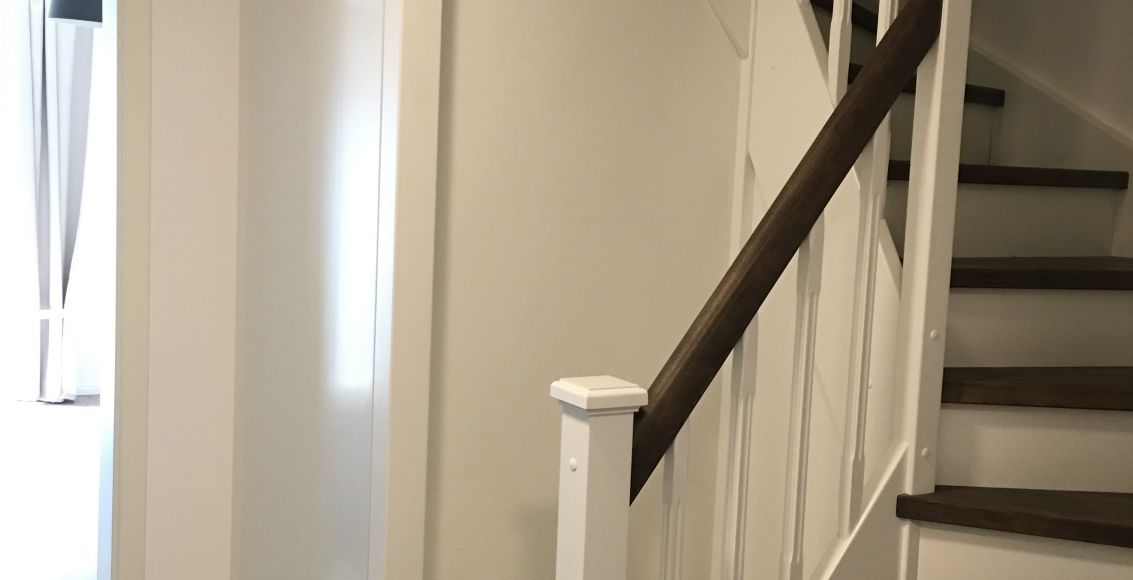 Farbige geschlossene Treppe mit Verkleidung und Tür zum Keller