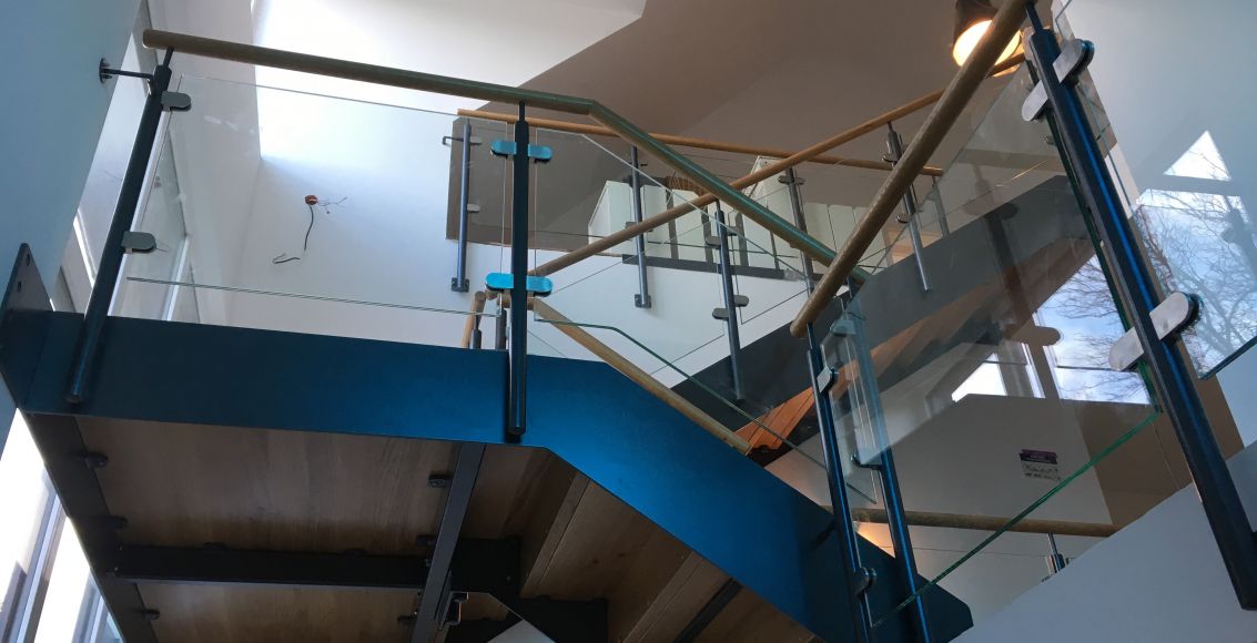 Stahltreppe mit Glas und Holzhandlauf