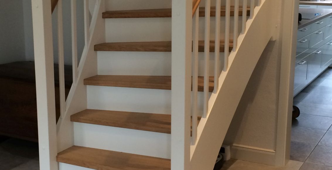 Geschlossene Treppe in weiß mit farbig geölten Stufen